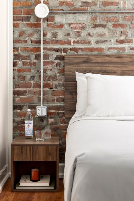 Hotel room — bed in foreground, windows looking out onto city